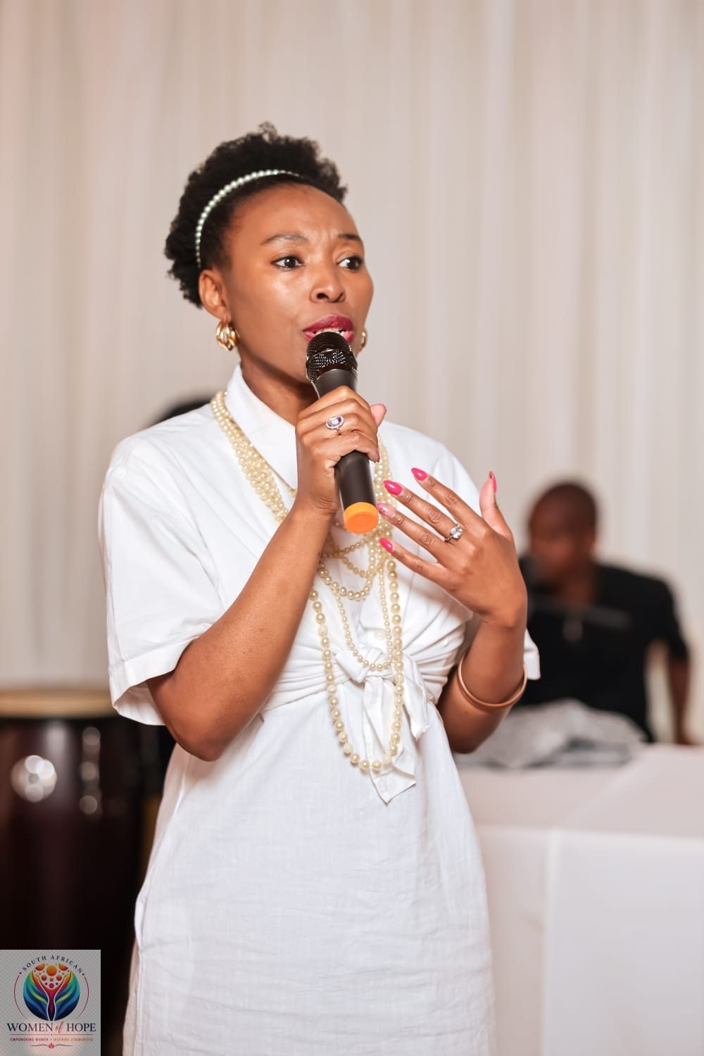 Lerato Senoko Dube addressing an audience with a microphone